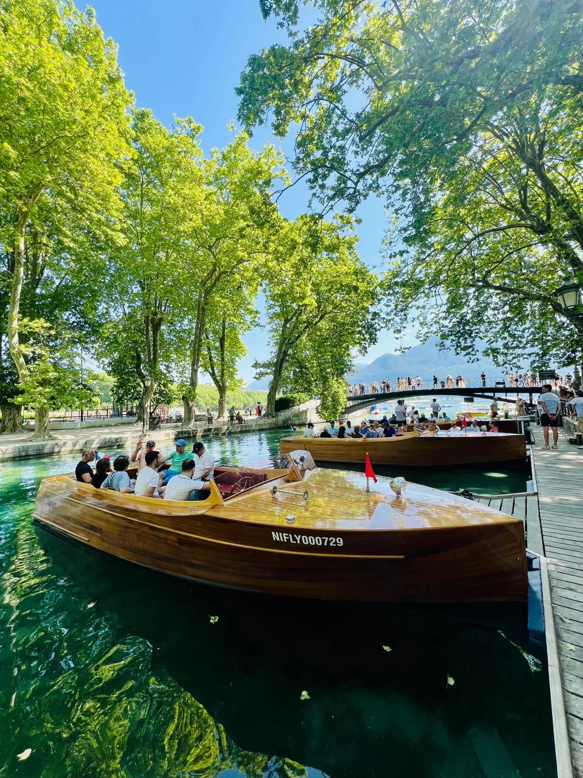 Bateaux en bois vernis amarrés sur le canal du Vassé à Annecy, sous les platanes